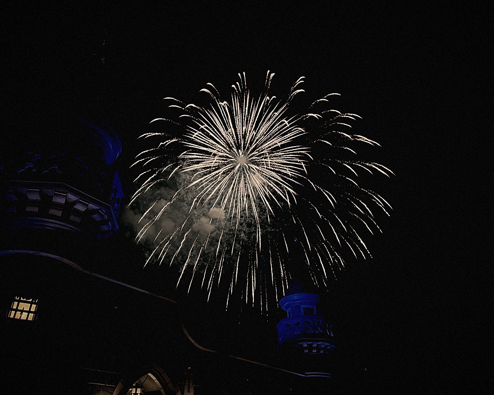 Fireworks bursting above Cinderella Castle at night